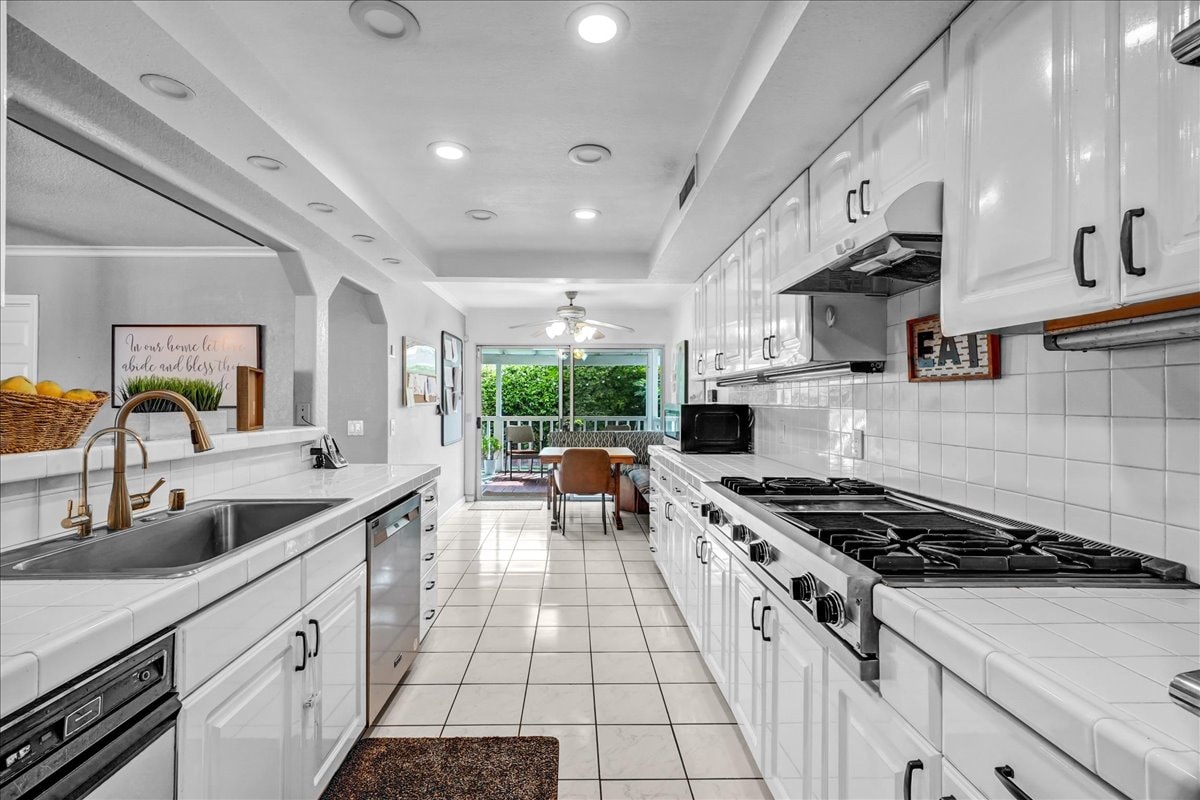 Galley kitchen with white cabinets and gas range at Blessings Senior Care South Birchleaf, Anaheim CA